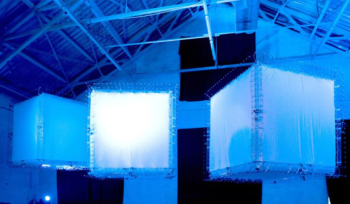 Photo de l'oeuvre Sommeil paradoxal de NXI Gestatio. Trois grands cubes de tissus blancs suspendus au profond d'un espace d'exposition de style hangar.