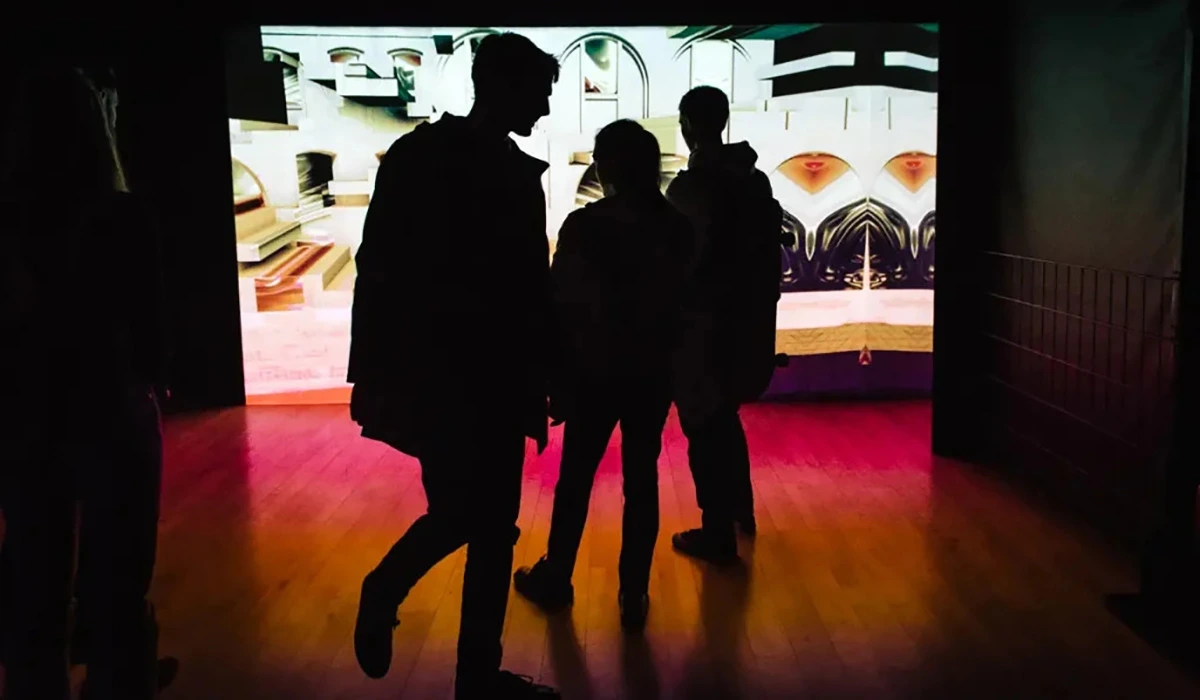 Trois silhouettes de visiteurs devant l'oeuvre Machine For Living de Sabrina Ratté.