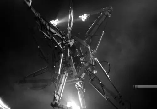 Photo en noir et blanc de l'œuvre Prehysterical Machine, par Bill Vorn. Installation robotique suspendue. Réalisée en 2002 et présentée lors de la 9e Festival international de Vidéo/Art/Électronique, Lima, en 2005.