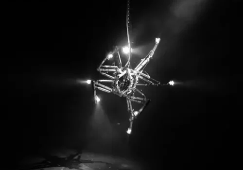 Photo en noir et blanc de l'œuvre Prehysterical Machine, par Bill Vorn. Installation robotique suspendue. Réalisée en 2002 et présentée lors de la 9e Festival international de Vidéo/Art/Électronique, Lima, en 2005.