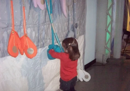 Photo d'une enfant interagissant avec l'œuvre Courtepointe d’hiver, par Mouna Andraos, 2010. Présenté lors des ateliers de fabrication fou de circuit, durant l’événement Technofolies au Centre des Sciences de Montréal, en 2011.